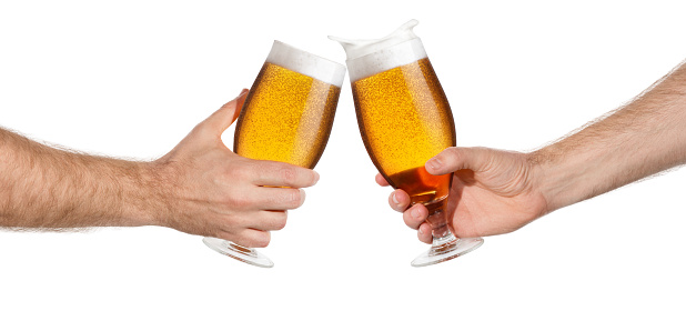 male hands with glass of beer toasting creating splash isolated on white background. Pair of beer glasses making toast. Beer up. Cheers
