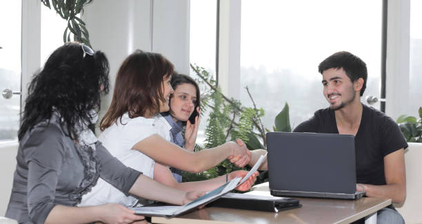 istock handshake colleagues sitting at the workplace 899092232