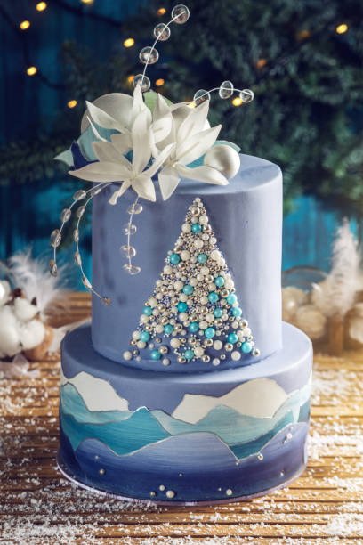 abgestufte kuchen die blaue torte mit dem bild von einem weihnachtsbaum und weißen blüten an der spitze. konzept der festliche desserts - christmas wedding bride winter stock-fotos und bilder