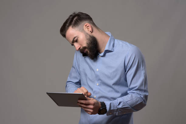 istock Hardworking multitasking busy business man cradling mobile phone on shoulder talking and using tablet computer 899096072