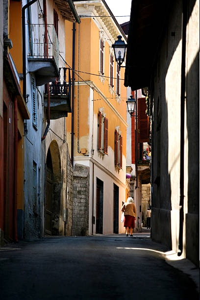 Italian street wtih old woman walking stock photo