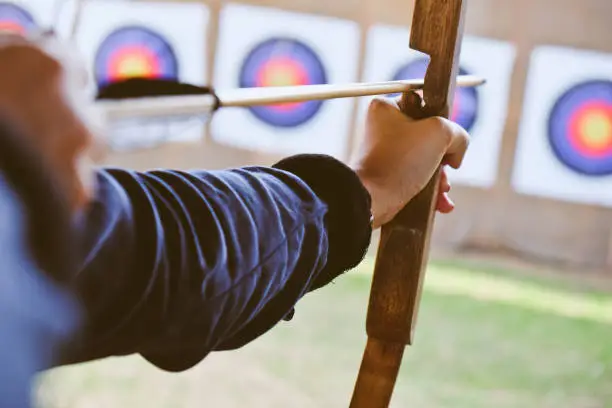Photo of Archer holds his bow aiming at a target
