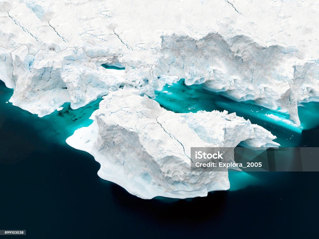 Aerial view of icebergs on Arctic Ocean in Greenland Arctic Icebergs Greenland in the arctic sea. You can easily see that iceberg is over the water surface, and below the water surface. Sometimes unbelievable that 90% of an iceberg is under water Aerial View Stock Photo