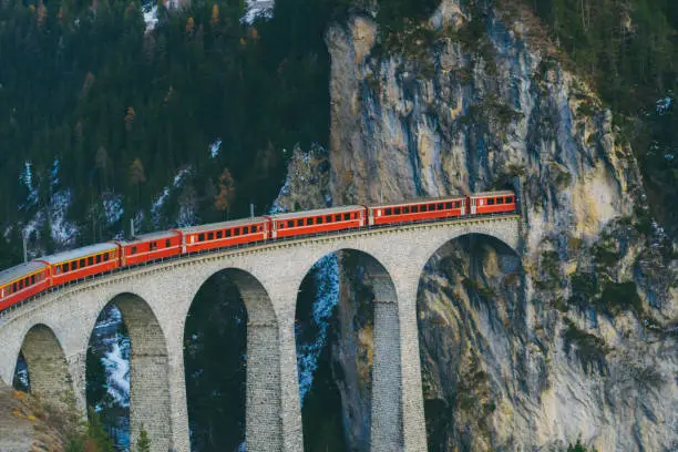 Scenic view of train on viaduct in Switzerland forest in winter