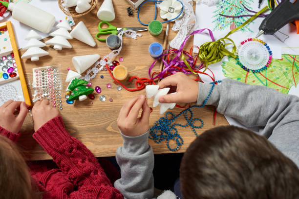 enfants faire artisanat et jouets, arbre de noël et autres. aquarelles de peinture. vue de dessus. oeuvre au travail avec accessoires créatifs. outils d’art plat laïcs. - christmas tree paint equipment work tool photos et images de collection