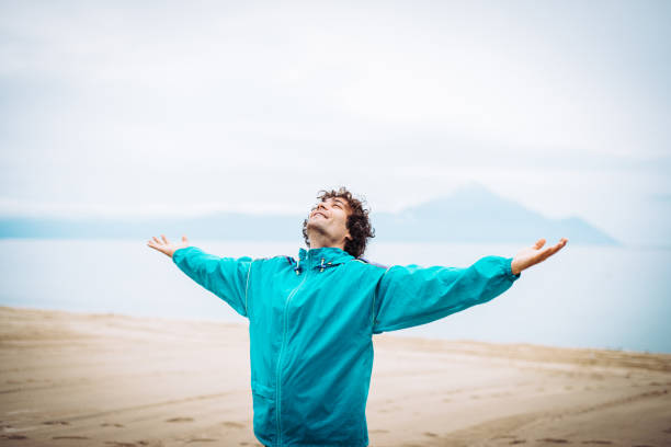 Breathing exercise on the sea shore Sportsmen and athletes having trainings on sea side during early spring and autumn. Recreation and exercising on sandy beach near the sea. mental strength stock pictures, royalty-free photos & images