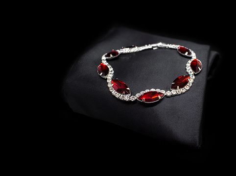 Jewellery silver ruby diamonds bracelet isolated on black cloth background