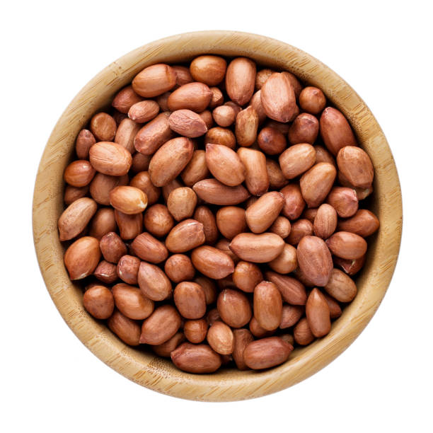 arachidi in ciotola di legno, isolate su bianco, vista dall'alto. - peanut bowl nut circle foto e immagini stock