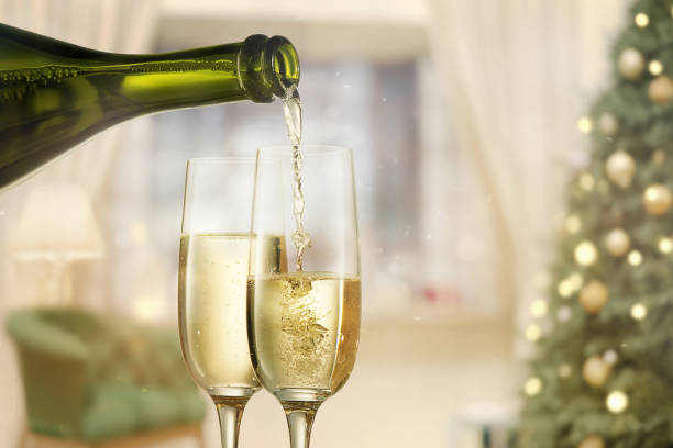 istock Glasses with champagne and bottle over sparkling holiday background 899113786