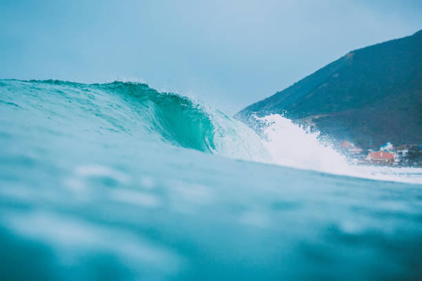 istock Blue wave in ocean. Surfing swell and cloudy sky 899114022