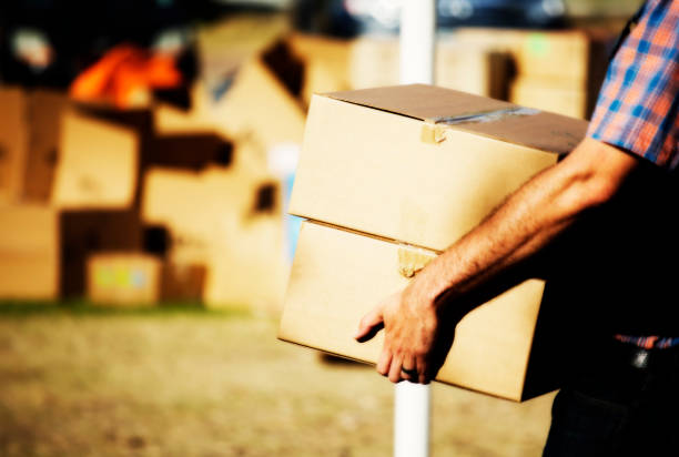 istock Man carries cardboard boxes with space for copy space 899116662