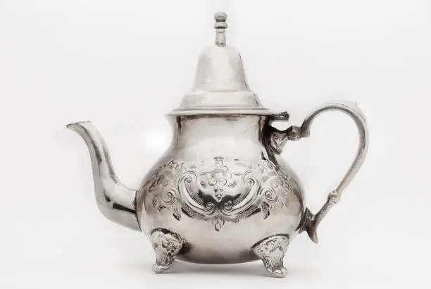 traditional moroccan metalic teapot on white background with a soft shade