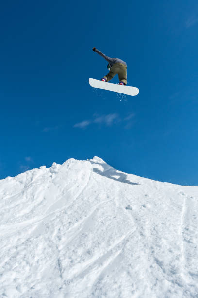 istock Snowboarder jumping against blue sky 899117712