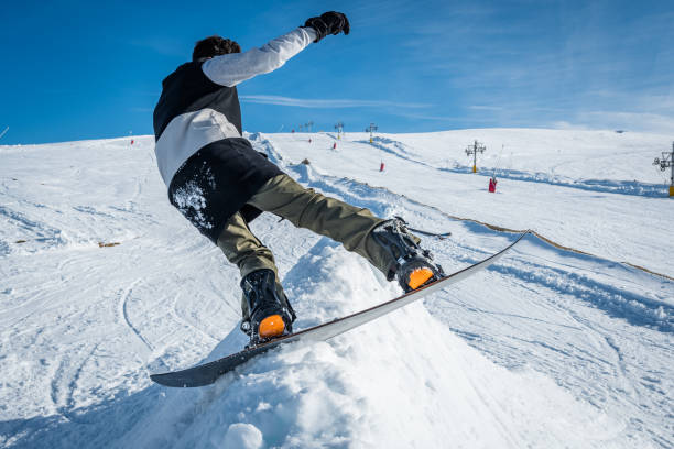 istock Snowboarder sliding against blue sky 899117898
