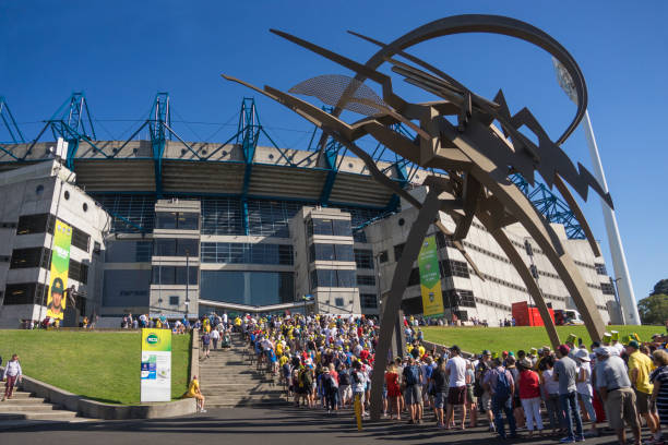 Melbourne, Australia - December 26, 2017: A long line of spectators queue outside the Melbourne Cricket Ground (MCG), as they await entry to watch a Boxing Day Test match between Australia and England. A steel sculpture by Anthony Pryor titled "The Legend" is also pictured.