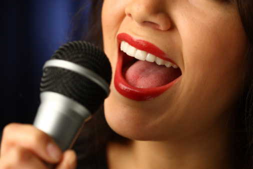 Close up of mouth singing into microphone