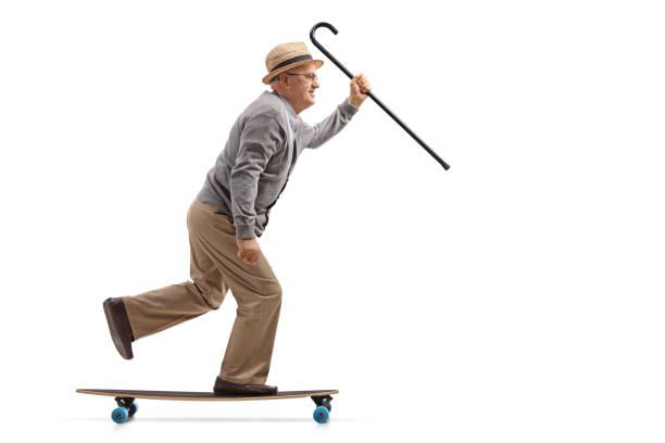 istock Mature man with a cane riding a longboard 899121850