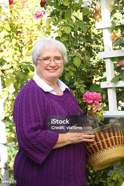 Donna Anziana Con Rose Garden - Fotografie stock e altre immagini di 60-69 anni - 60-69 anni, Adulto, Adulto in età matura