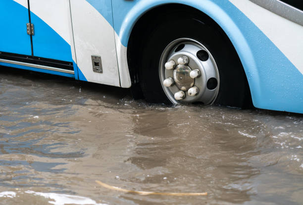 istock Bus splashes through a large puddle on a flooded street 899128718