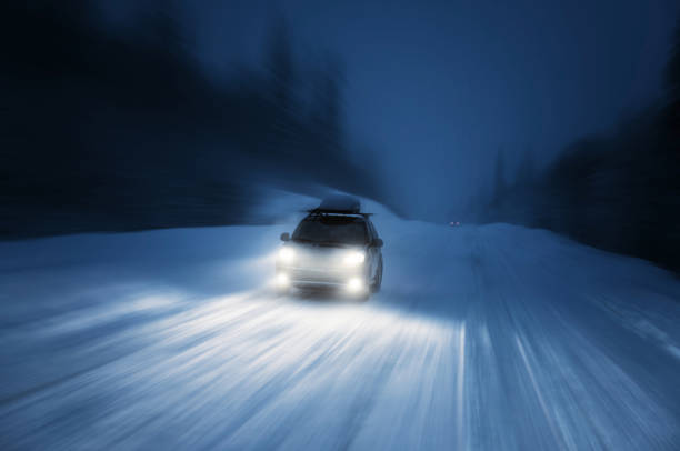 istock Car lights in winter forest 899130386
