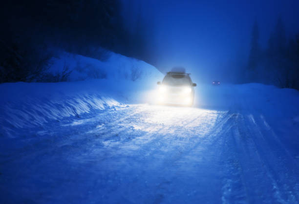 istock Car lights in winter forest 899130388