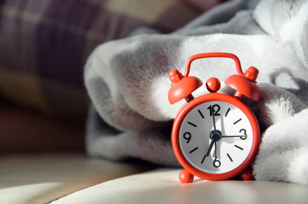 Bedside alarm clock with morning light stock photo