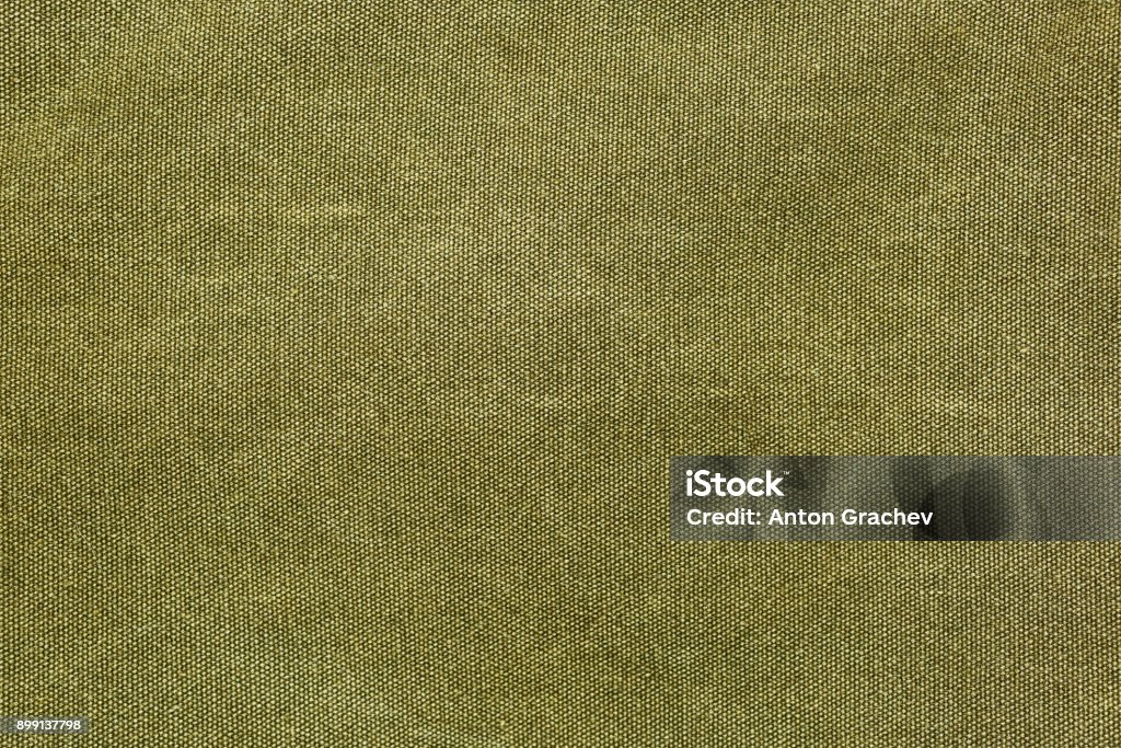 Rough olive canvas texture Horizontal piece of rough canvas fabric, olive colored. Vintage style unevenly painted dense textile with traces of usage. Textile Stock Photo