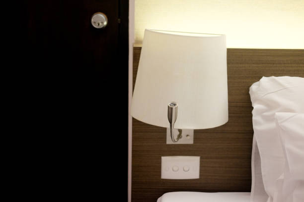 istock Lamp near bed with pillows in bedroom 899144726