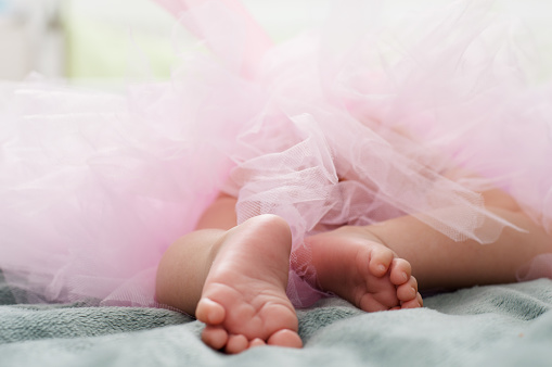 Little barefoot of ballerina in pink tutu.