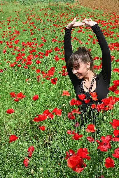 Young woman on the poppy meadow