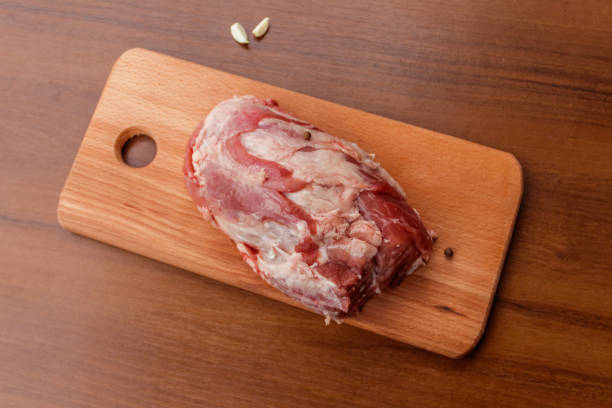 istock Raw pork meat on cutting board on a table. Top view 899172498