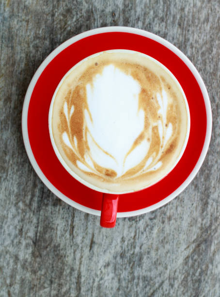 istock Top view latte art coffee isolate on wooden background. Red cup. 899174558