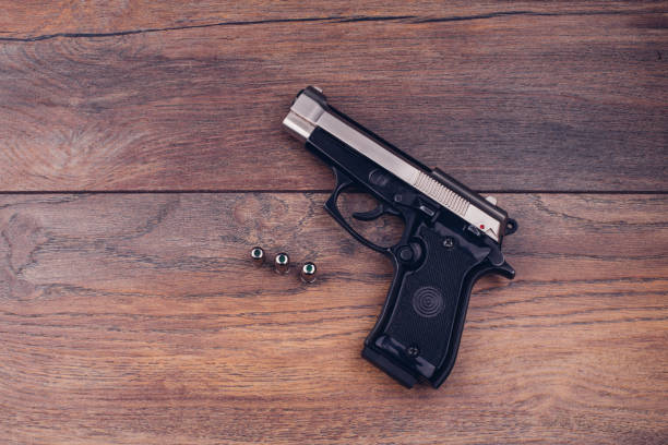 Beside view of black M1911 semi-automatic .45 caliber pistol isolated on white background, 3D rendering