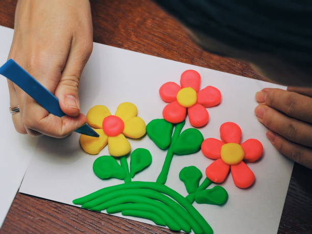istock clay therapy. plasticine therapy. a boy sculpt clay figures. the teacher help him 899183288