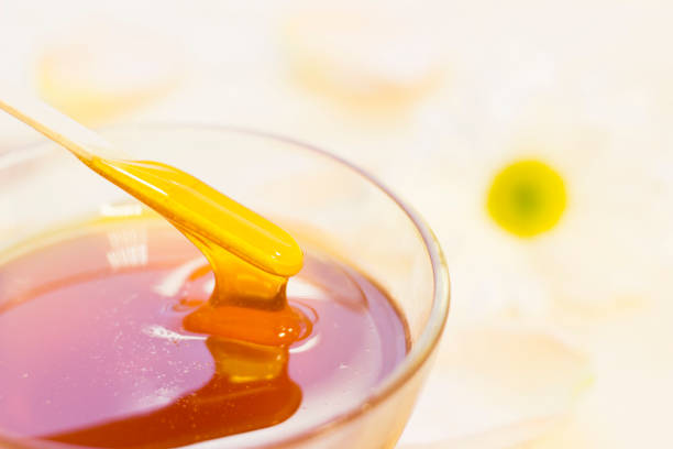 istock A bowl of honey with a camomile 899193158