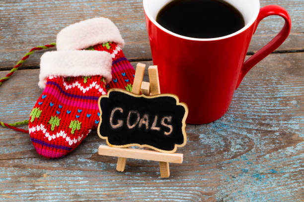 istock Goals - handwriting message on blackboard with a Cup of coffee and mittens, New Year resolutions concept 899199782