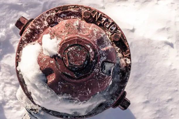 Photo of View from above of a fire hydrant, surrounded by snow and ice