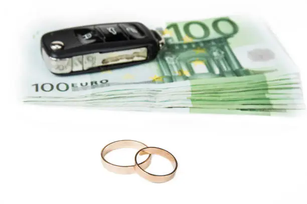 Gold digger concept. Money, car and wedding rings.