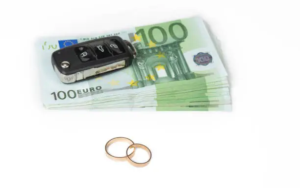 Gold digger concept. Money, car and wedding rings.