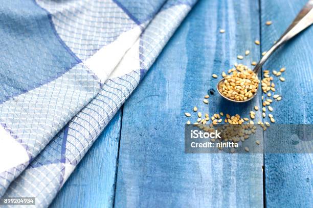 Metal Spoon Of Sesame On Blue Wood Table Stock Photo - Download Image Now - Algeria, Aromatherapy, Baby Spoon