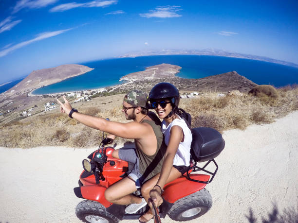 couple exploring the island young couple driving a quad having fun and discovering the island paros stock pictures, royalty-free photos & images