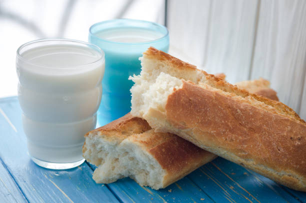 Two glasses of milk white and blue with bread