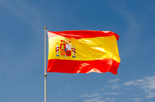 Spain flag waving on a blue sky. Spanish symbol