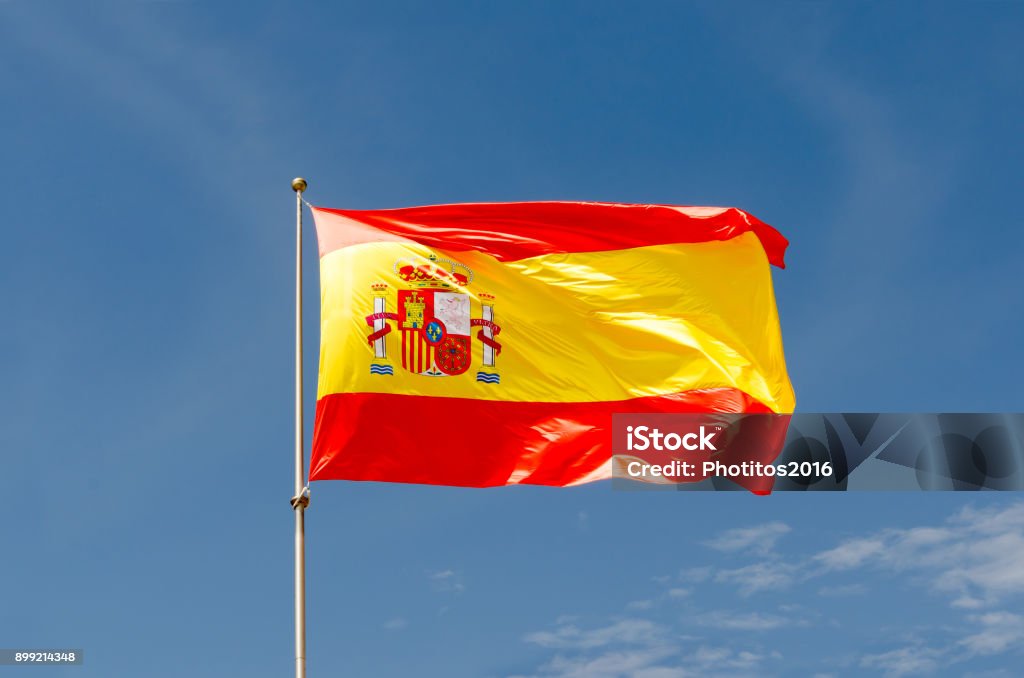 Bandeira de Espanha acenando em um céu azul - Foto de stock de Bandeira Espanhola royalty-free