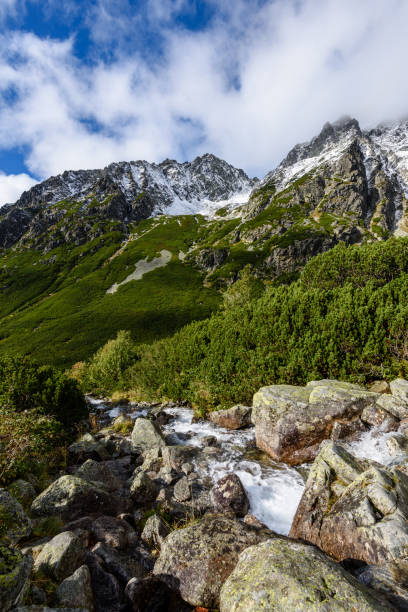 istock large Waterfall from ravine in autumn, long exposure with mountains in background 899215406