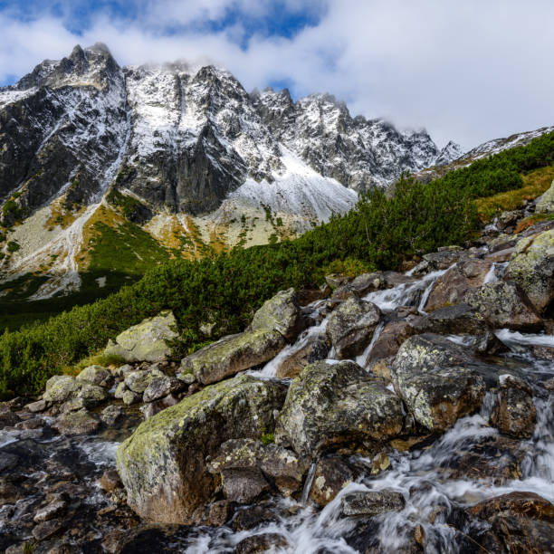 istock large Waterfall from ravine in autumn, long exposure with mountains in background 899215474