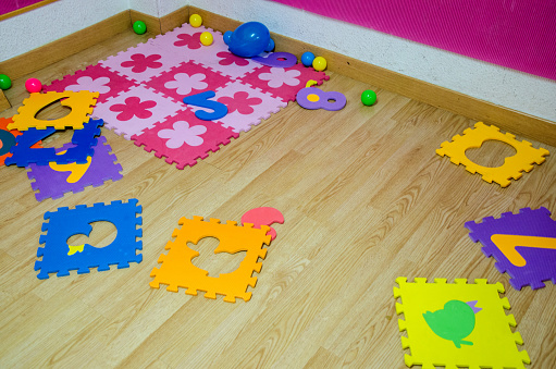 foam colorful puzzle pieces on the ground of the classroom of the school. Childhood education concept. back to school