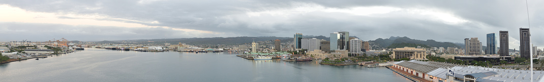 The entire harbor at Honolulu in the early morning including the industrial area, ships fairway, clock tower and skyline of modern office buildings