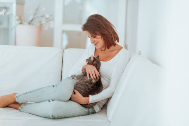 istock beautiful young middle aged woman resting, drinking tea and reading on a white sofa surrounded by the white interior 899225122