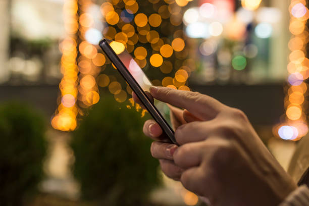 istock Woman using Mobile Phone in the street before christmas 899226838